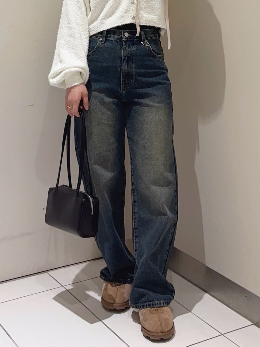 ホワイト系のニット/セーター、ブルー系のデニムパンツ、ブラック系のショルダーバッグを着用したレディースの冬コーディネートの3枚目の写真