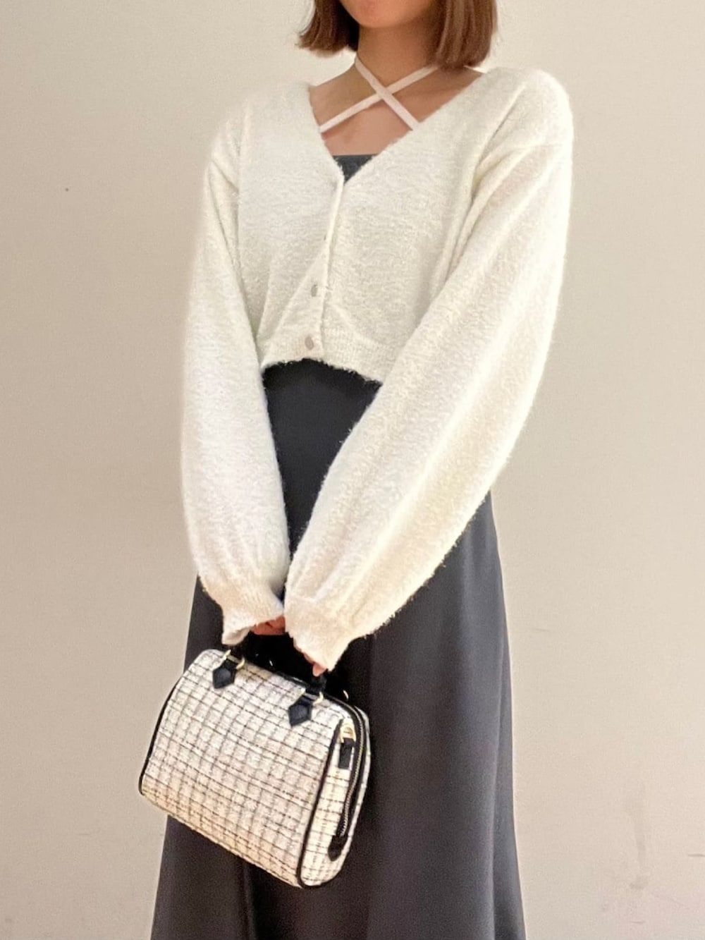 ホワイト系のニット/セーター、グレー系のワンピース、ホワイト系のボストンバッグを着用したレディースの冬コーディネートの2枚目の写真