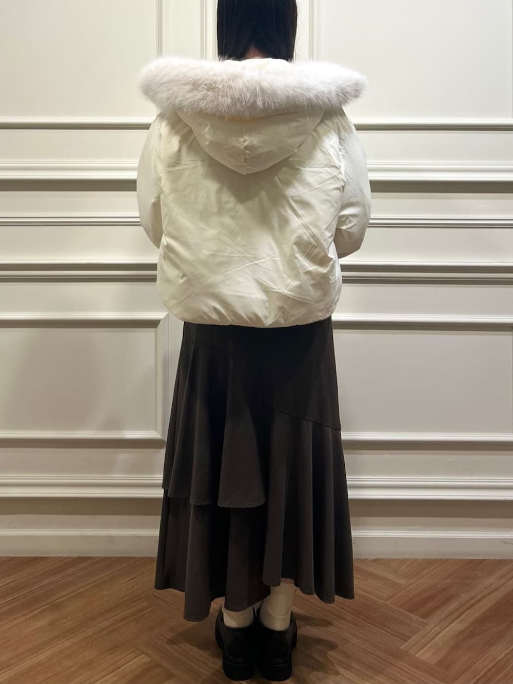 ホワイト系のブルゾン、ブラウン系のスカート、ブルー系のカーディガン/ボレロを着用したレディースの秋コーディネートの2枚目の写真