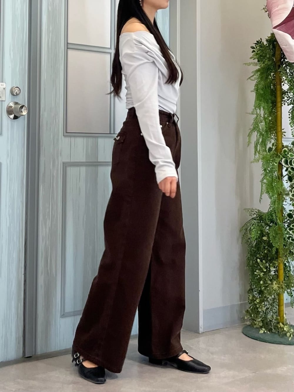 グレー系のTシャツ/カットソー、ブラウン系のデニムパンツ、ブラック系のパンプスを着用したレディースの秋コーディネートの2枚目の写真