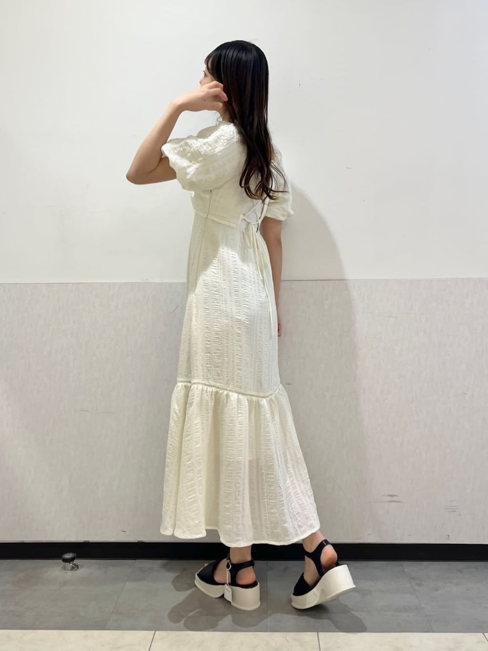 ホワイト系のワンピース、ブラック系のサンダルを着用したレディースの夏コーディネートの2枚目の写真