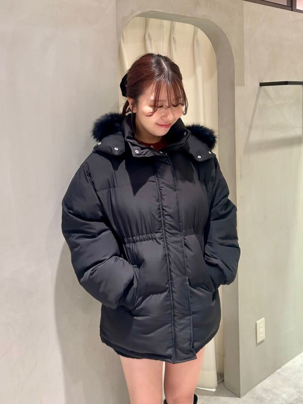 ブラック系のダウンジャケット/コート、ブラウン系のブーツ、グレー系のショルダーバッグを着用したレディースの冬コーディネートの3枚目の写真