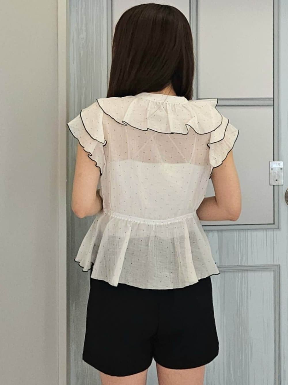ブラック系のパンプス、ホワイト系のボストンバッグ、ホワイト系のシャツ/ブラウスを着用したレディースの夏コーディネートの3枚目の写真