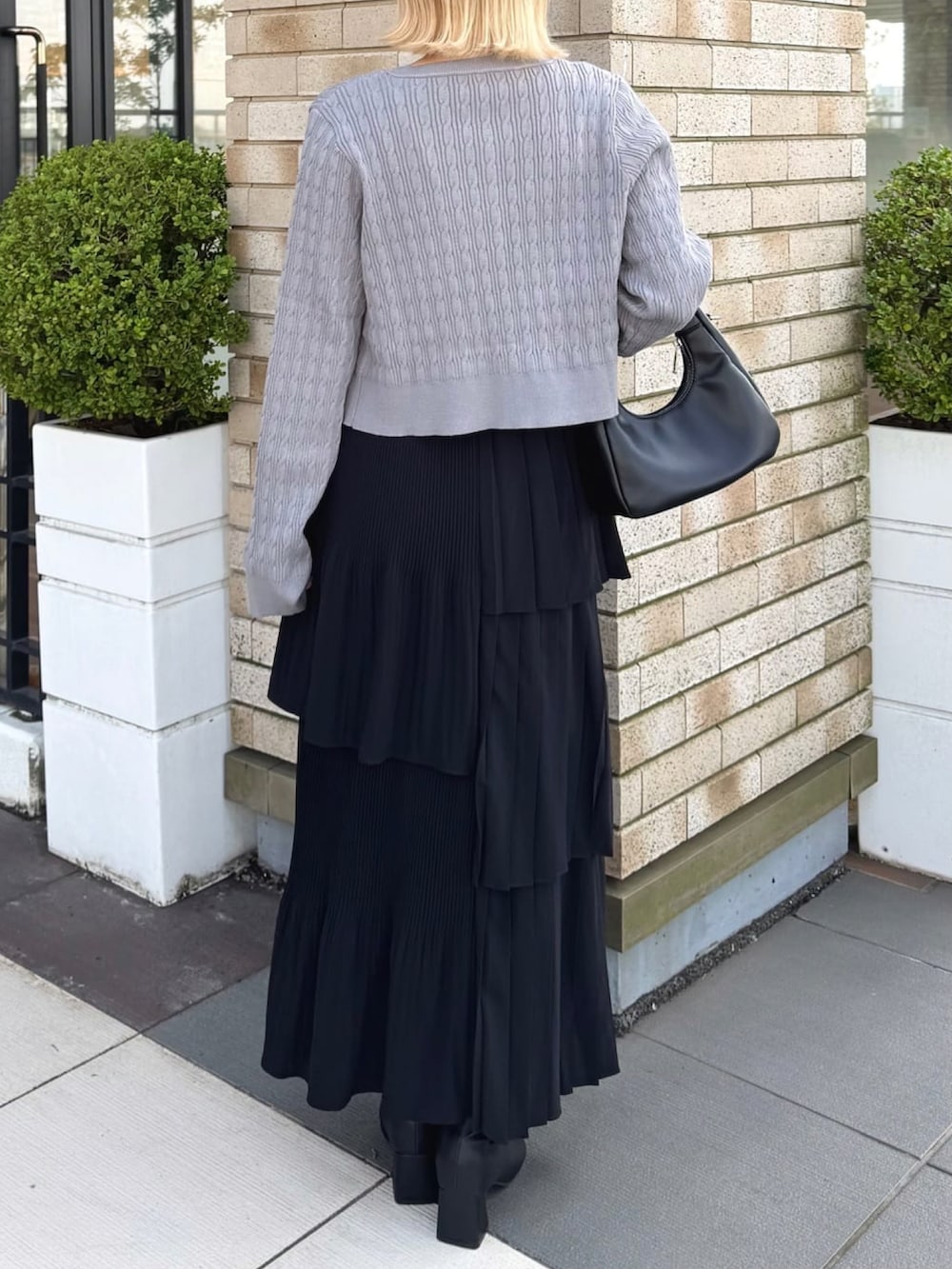 グレー系のカーディガン/ボレロ、ブラック系のスカートを着用したレディースの秋コーディネートの3枚目の写真