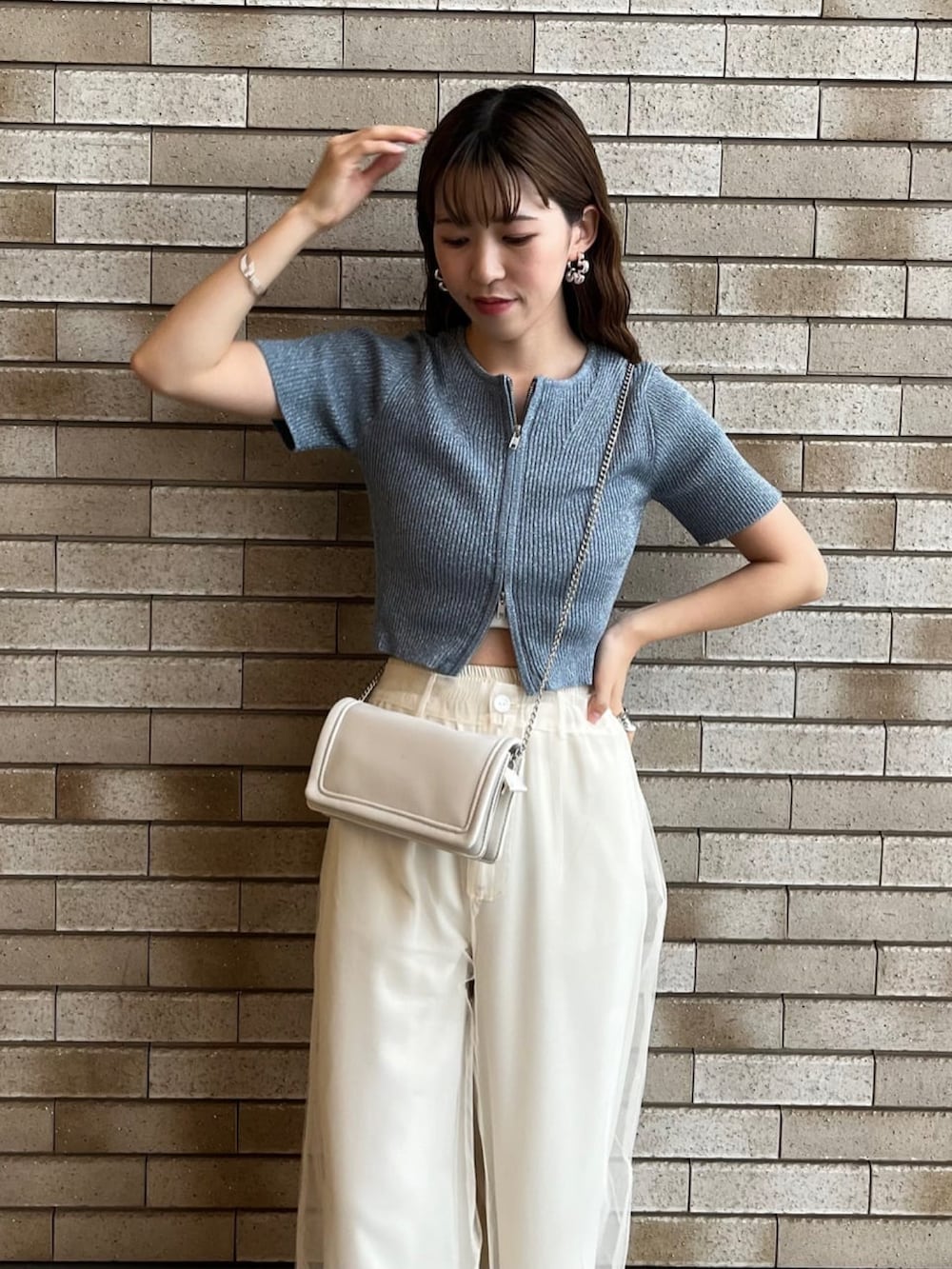 ブルー系のニット/セーター、ホワイト系のその他パンツ、グレー系のサンダルを着用したレディースの夏コーディネートの3枚目の写真