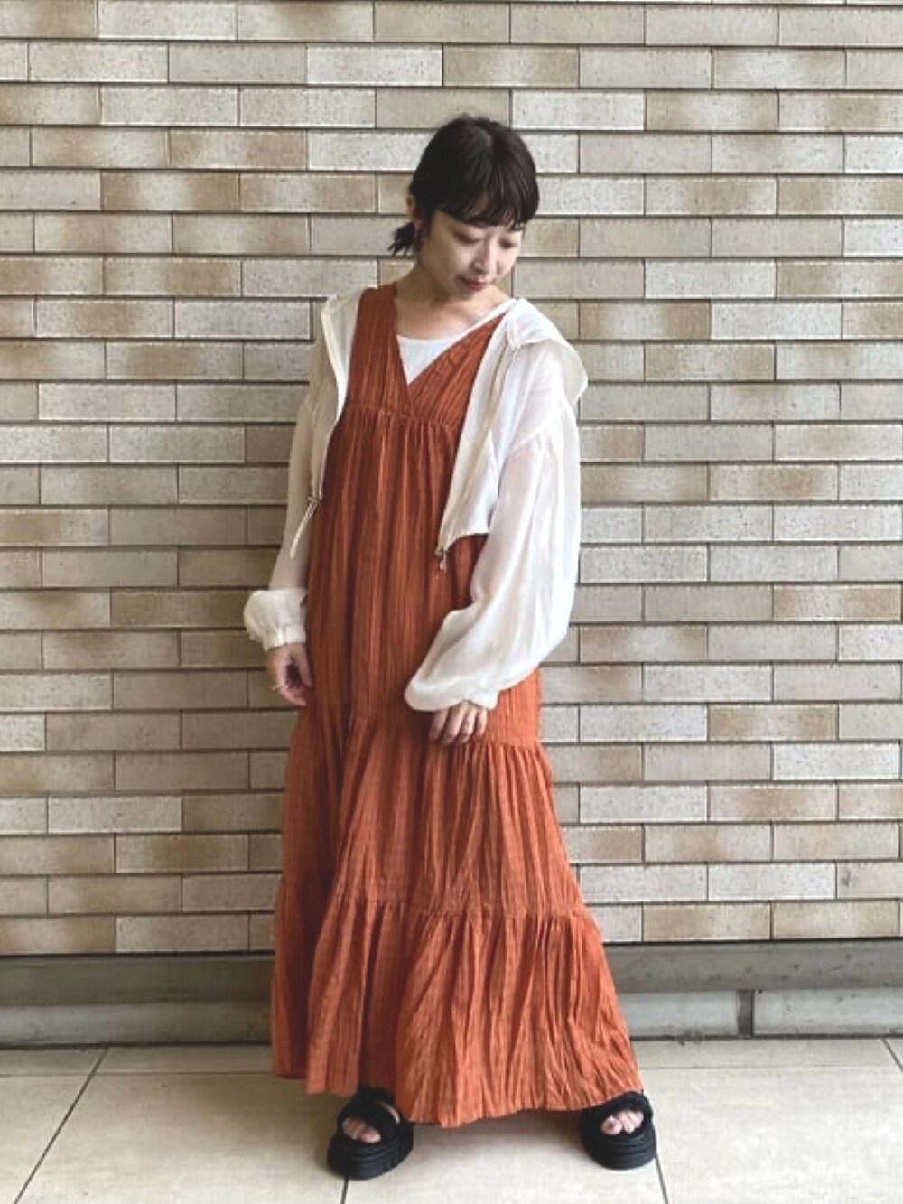 レッド系のワンピース、ブラック系のサンダルを着用したレディースの夏コーディネートの3枚目の写真