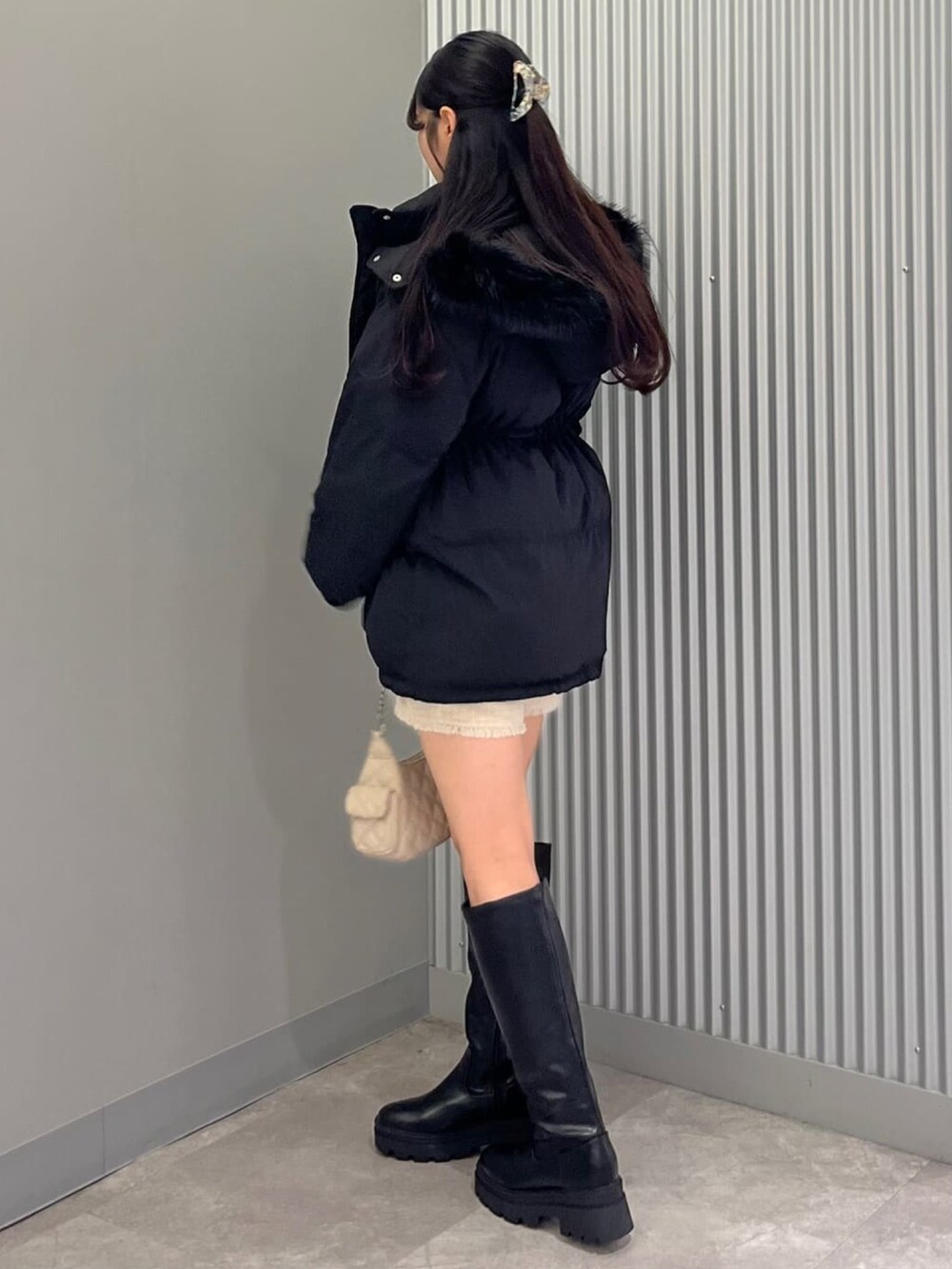 ブラック系のブルゾン、ホワイト系のその他パンツ、ブルー系のカーディガン/ボレロを着用したレディースの冬コーディネートの2枚目の写真