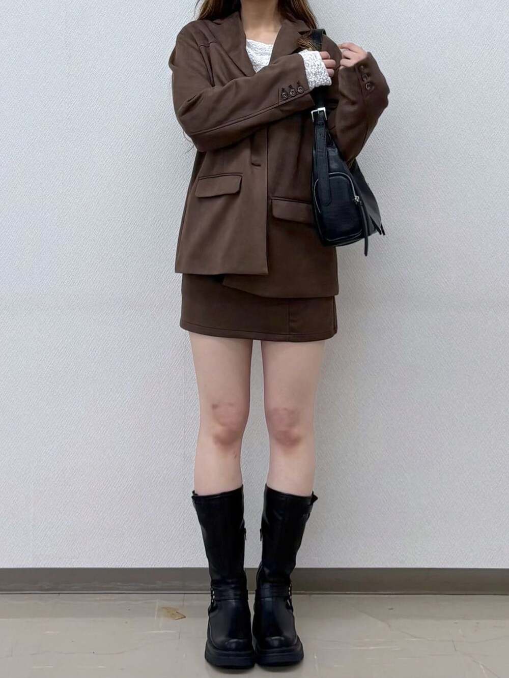 ブラウン系のテーラードジャケット、ブラウン系のスカートを着用したレディースの秋コーディネートの3枚目の写真