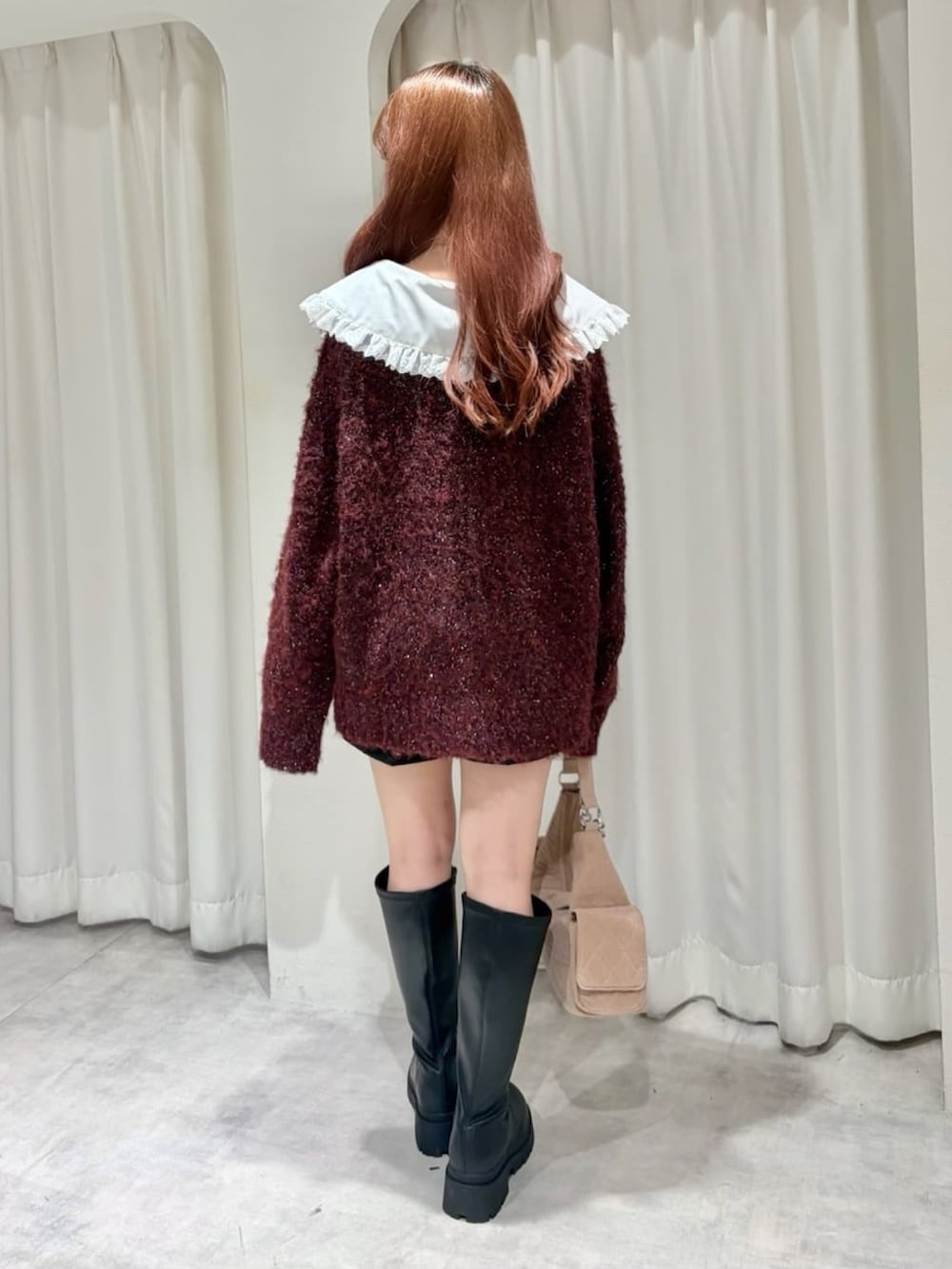 レッド系のカーディガン/ボレロ、ブラック系のその他パンツ、ブラック系のブーツを着用したレディースの秋コーディネートの3枚目の写真