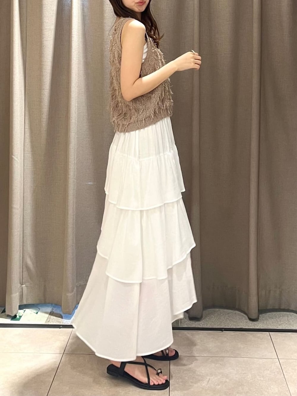 ブラウン系のベストを着用したレディースの夏コーディネートの2枚目の写真