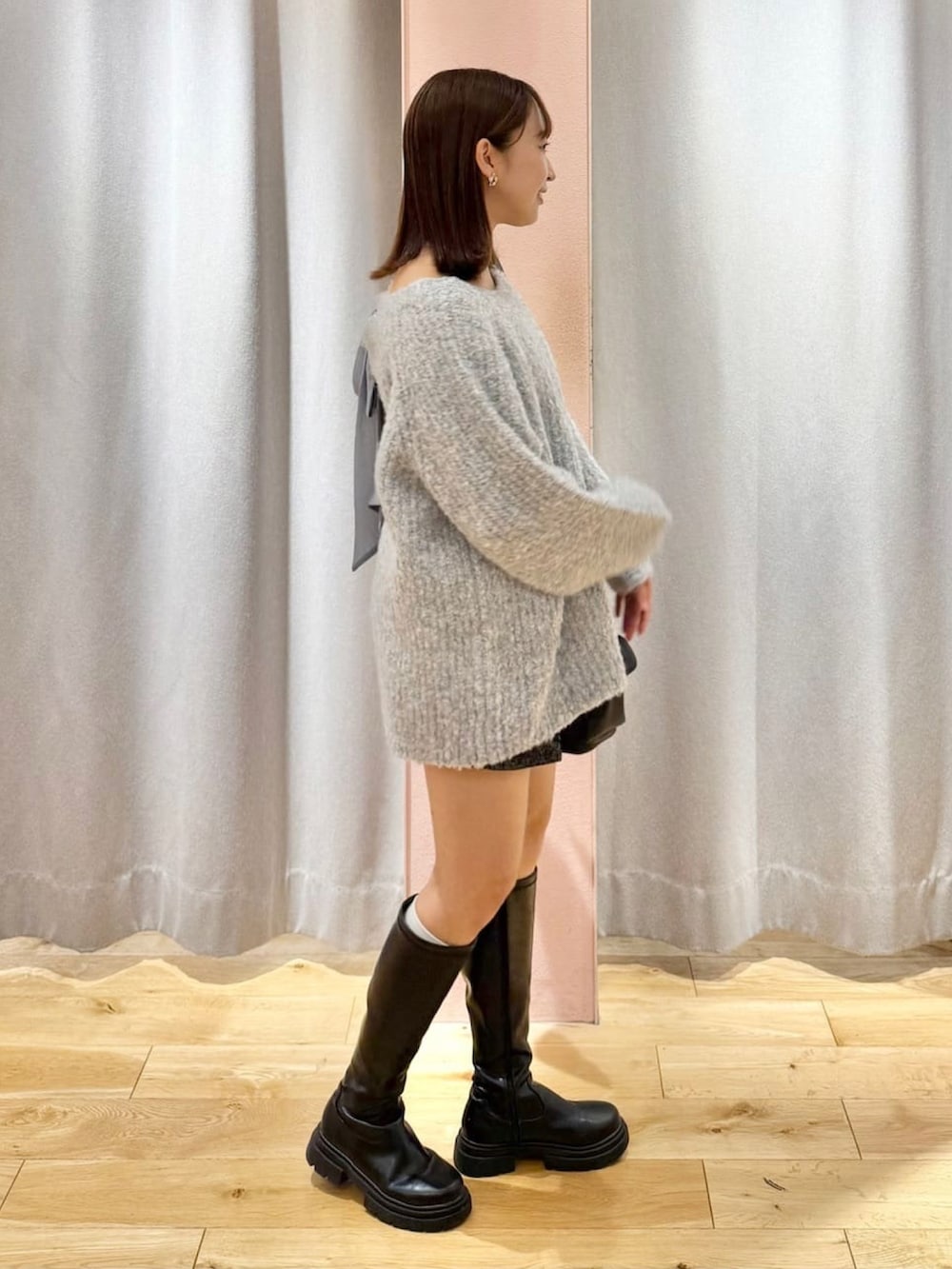 ブルー系のニット/セーター、ブラック系のショルダーバッグを着用したレディースの秋コーディネートの2枚目の写真