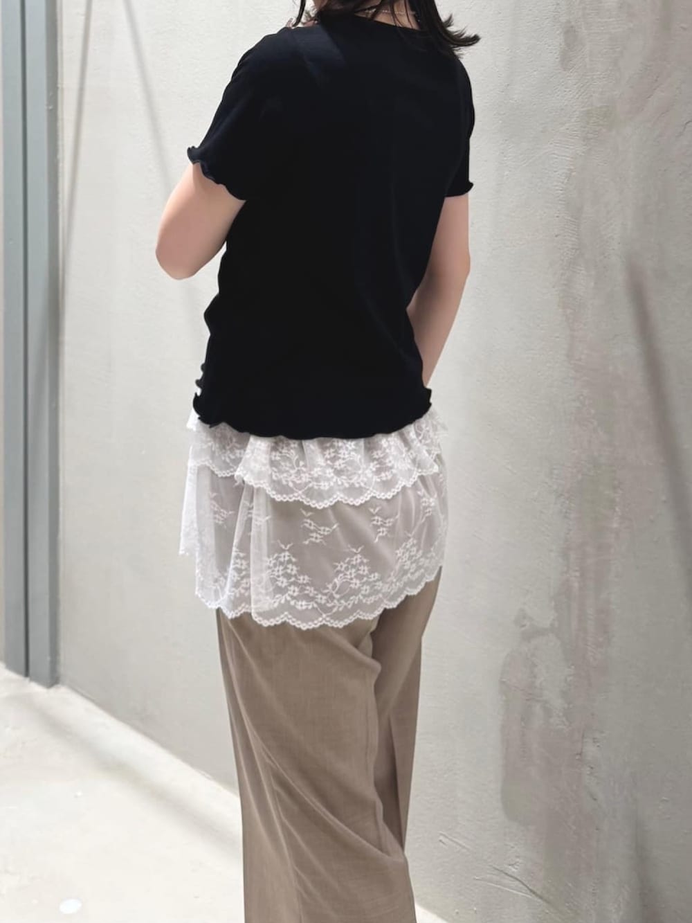 ブラック系のTシャツ/カットソー、ベージュ系のスラックスを着用したレディースの夏コーディネートの3枚目の写真