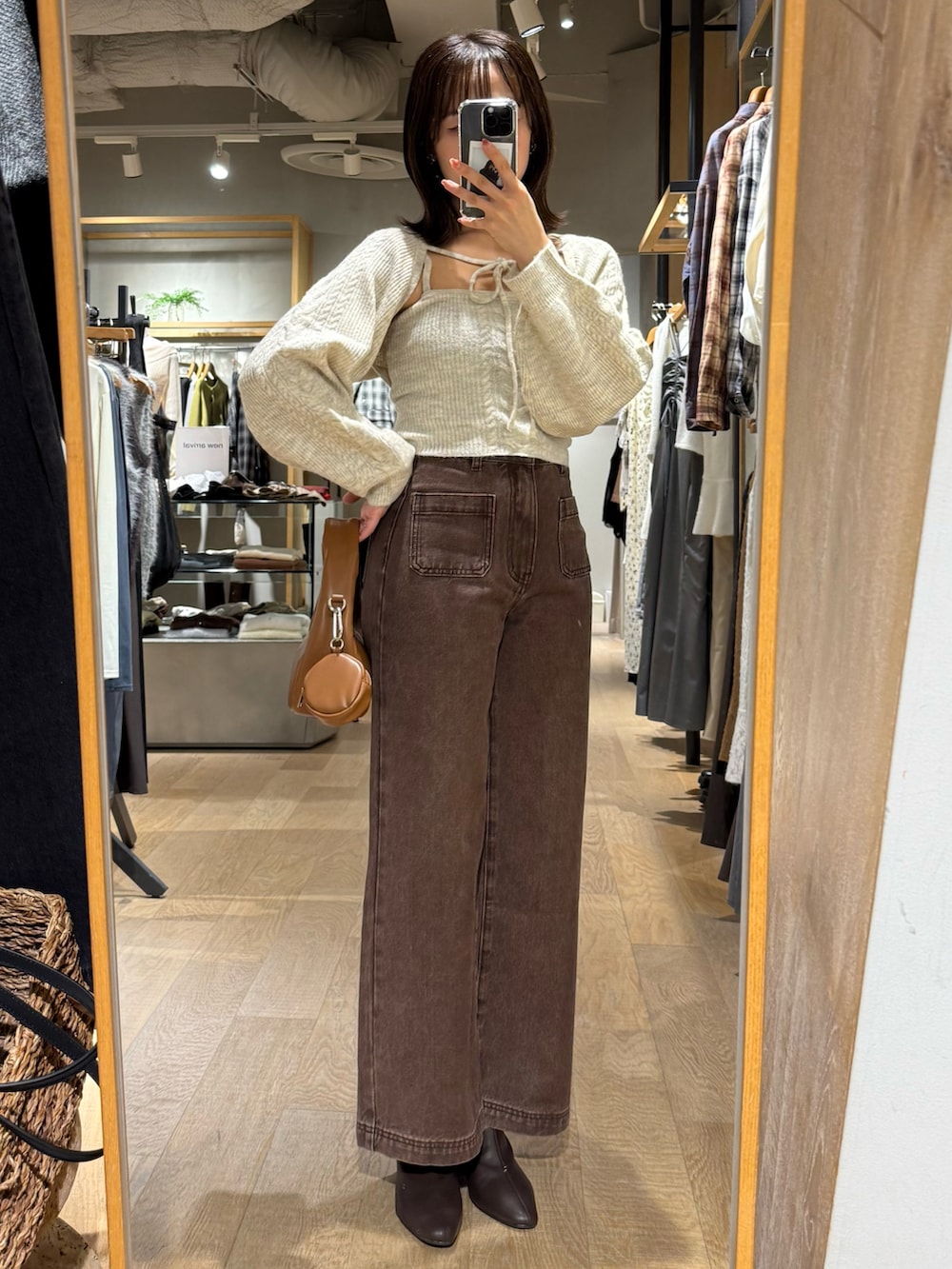 ホワイト系のアンサンブル、ブラウン系のデニムパンツを着用したレディースの秋コーディネートの2枚目の写真