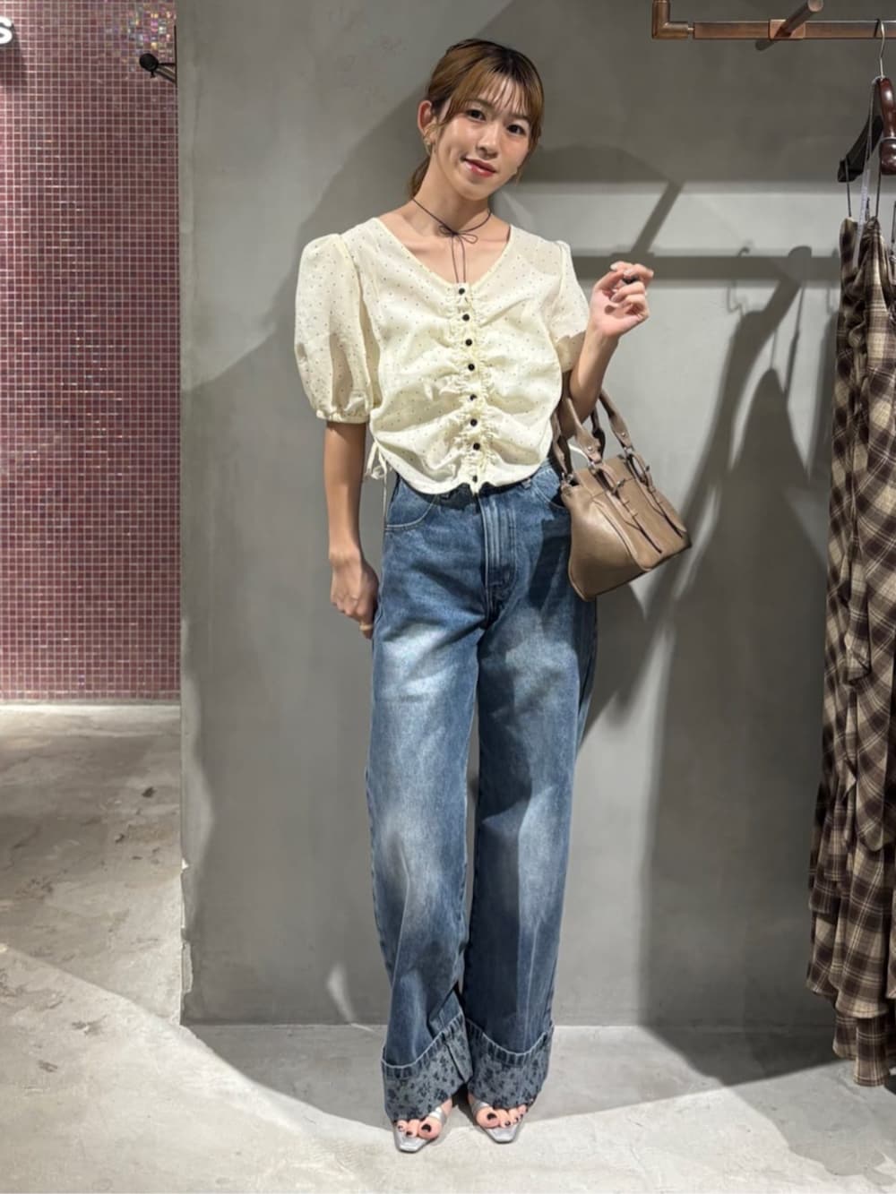 ブルー系のデニムパンツ、ホワイト系のシャツ/ブラウス、ブラウン系のショルダーバッグを着用したレディースの夏コーディネートの5枚目の写真