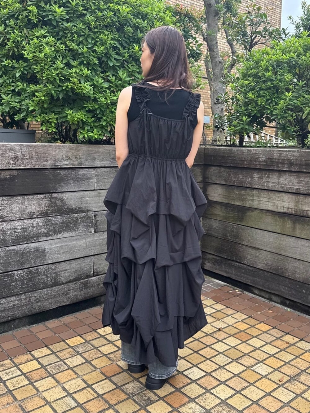 ブラック系のワンピース、ブルー系のデニムパンツ、ブラック系のボストンバッグを着用したレディースの夏コーディネートの3枚目の写真