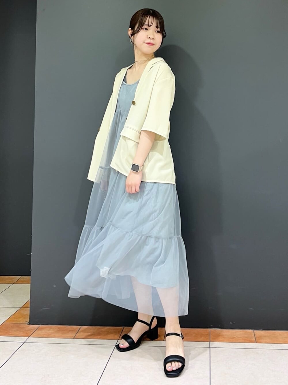ホワイト系のテーラードジャケット、グレー系のワンピース、ホワイト系のサンダルを着用したレディースの夏コーディネートの2枚目の写真