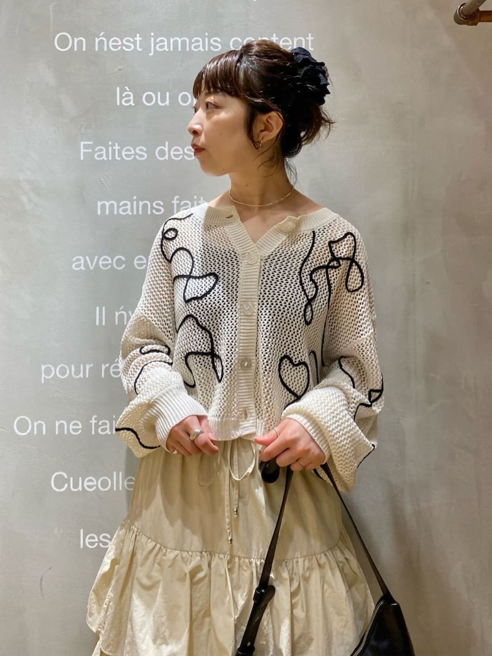 ホワイト系のカーディガン/ボレロ、ベージュ系のスカートを着用したレディースの春コーディネートの3枚目の写真