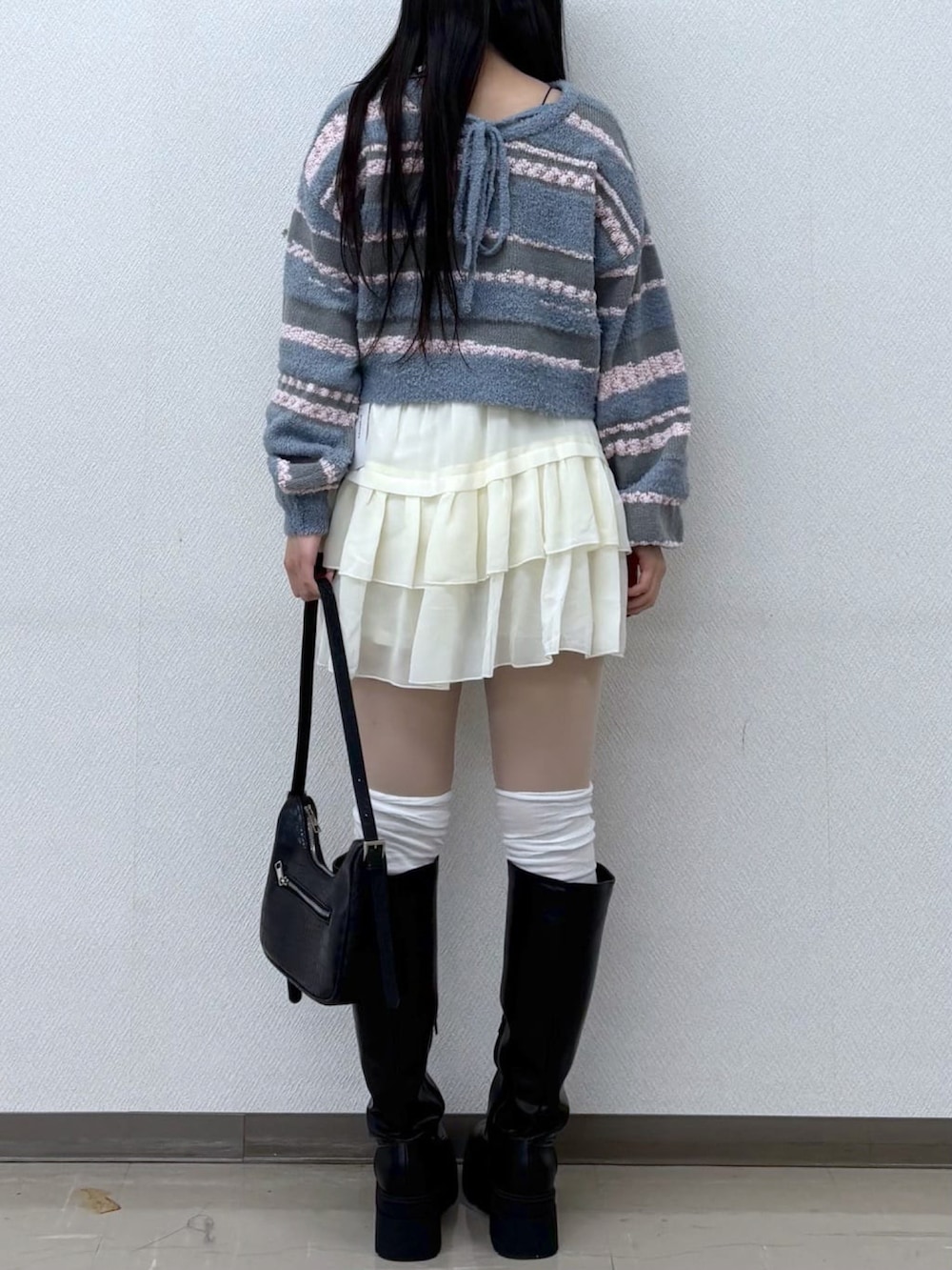 ブルー系のニット/セーター、ホワイト系のスカートを着用したレディースの冬コーディネートの2枚目の写真
