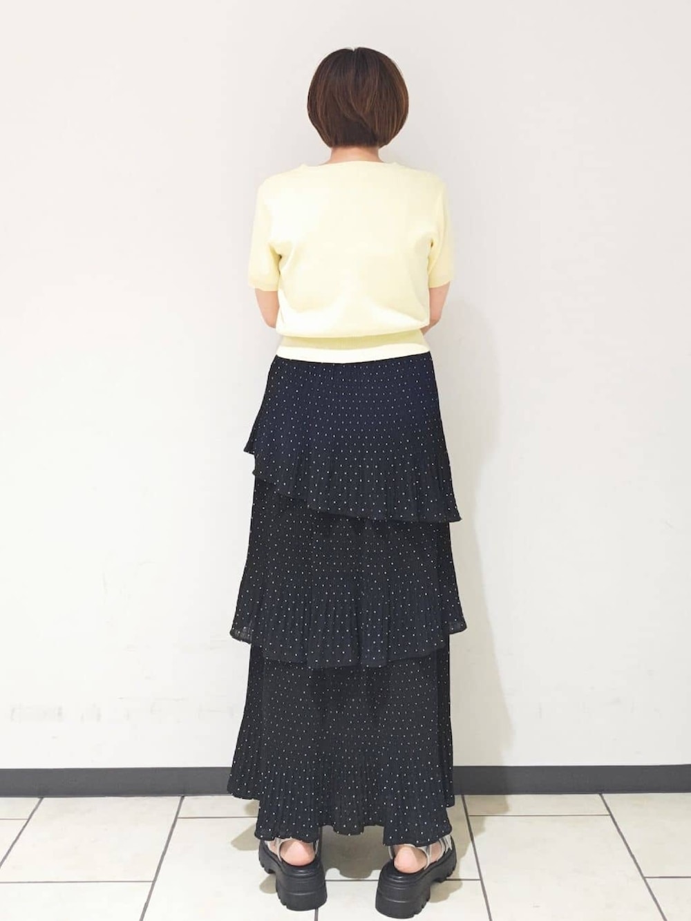 ブラック系のスカート、イエロー系のカーディガン/ボレロ、グレー系のサンダルを着用したレディースの夏コーディネートの3枚目の写真