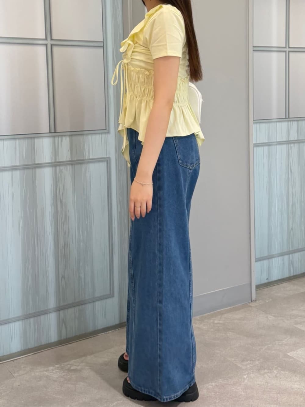 ブルー系のデニムパンツ、ベージュ系のTシャツ/カットソーを着用したレディースの夏コーディネートの3枚目の写真