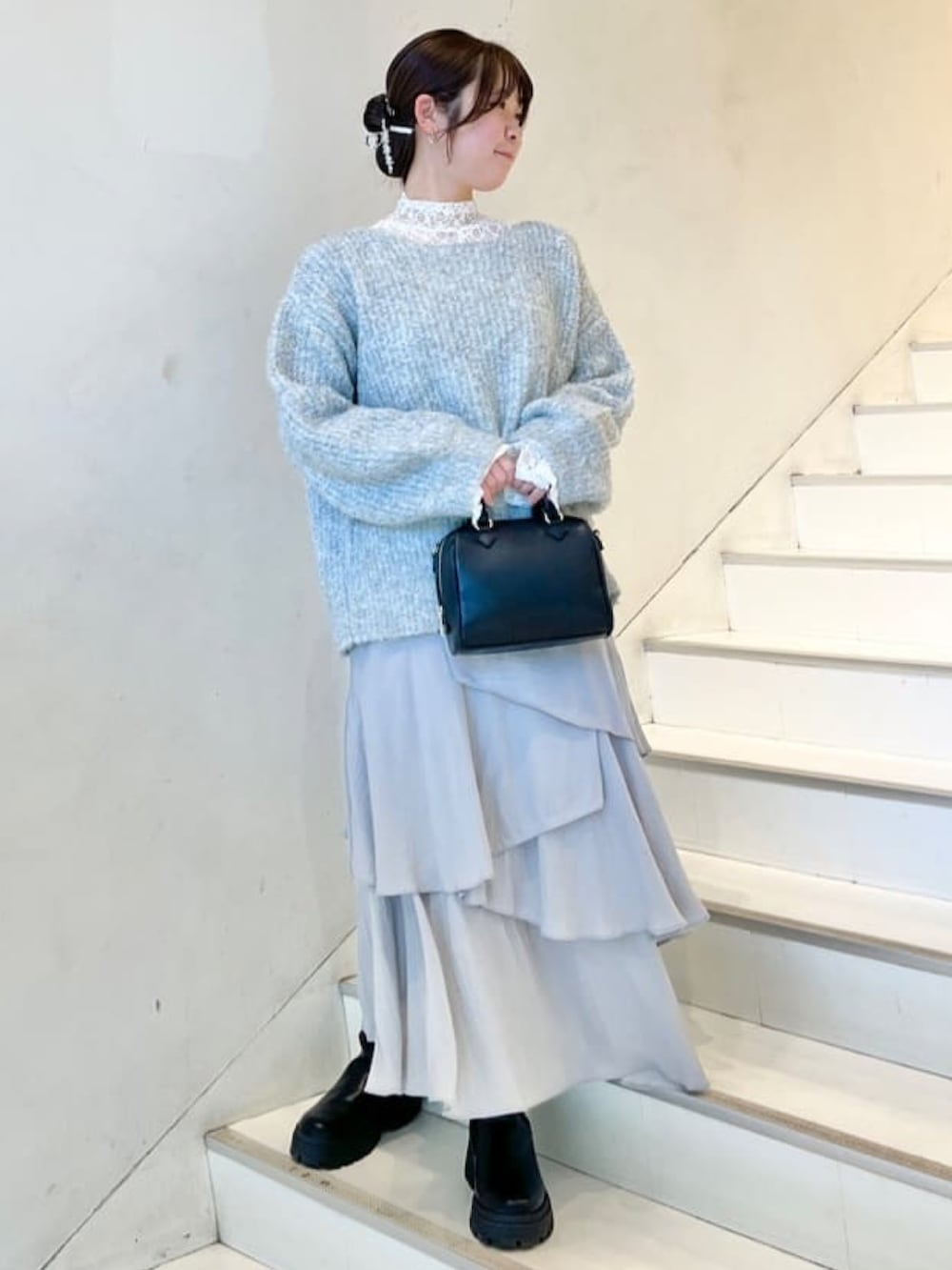 ブルー系のニット/セーター、ホワイト系のTシャツ/カットソー、グレー系のスカートを着用したレディースの冬コーディネートの2枚目の写真