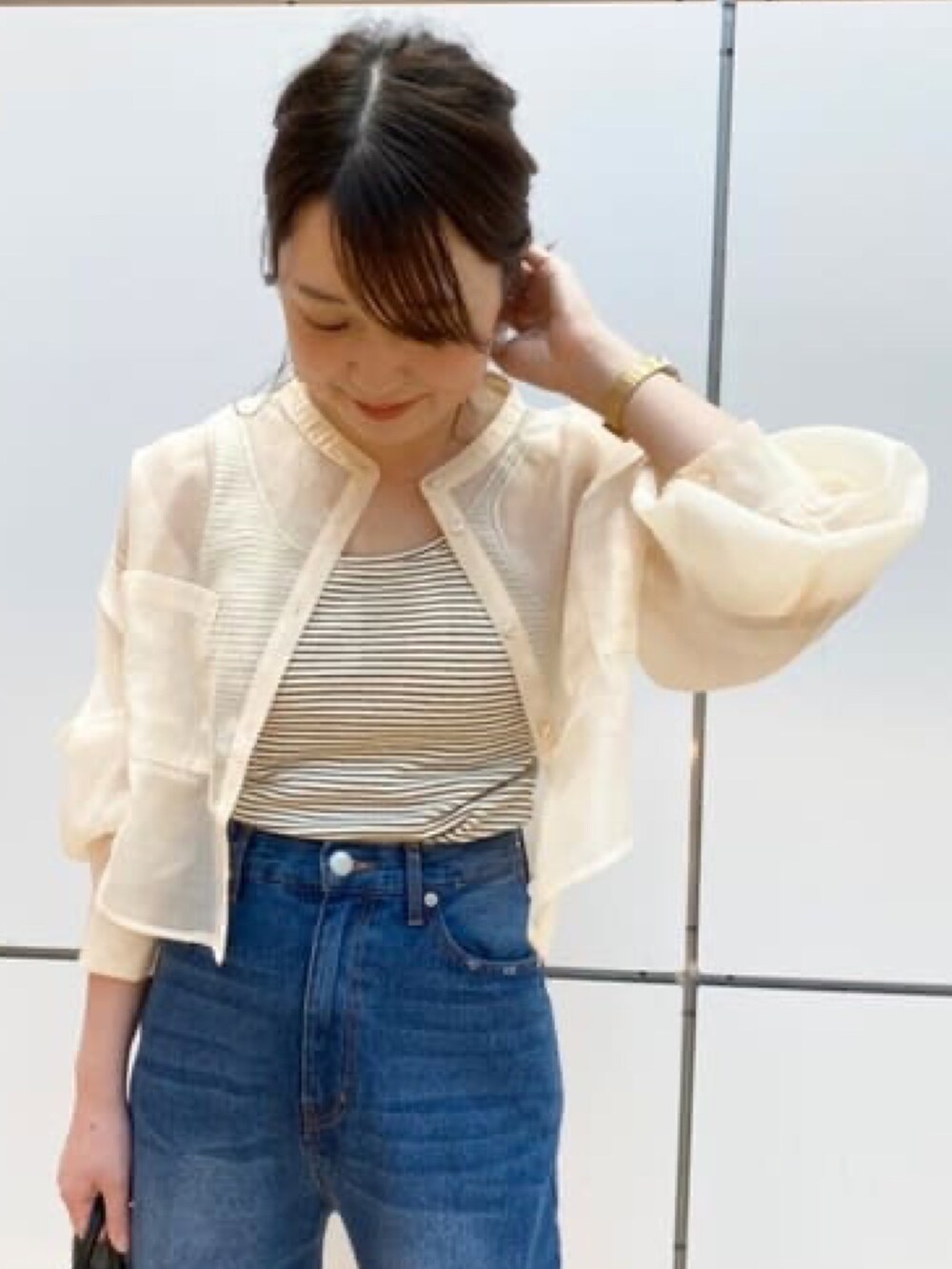 ホワイト系のシャツ/ブラウス、ブルー系のデニムパンツ、ブラック系のトートバッグを着用したレディースの夏コーディネートの2枚目の写真