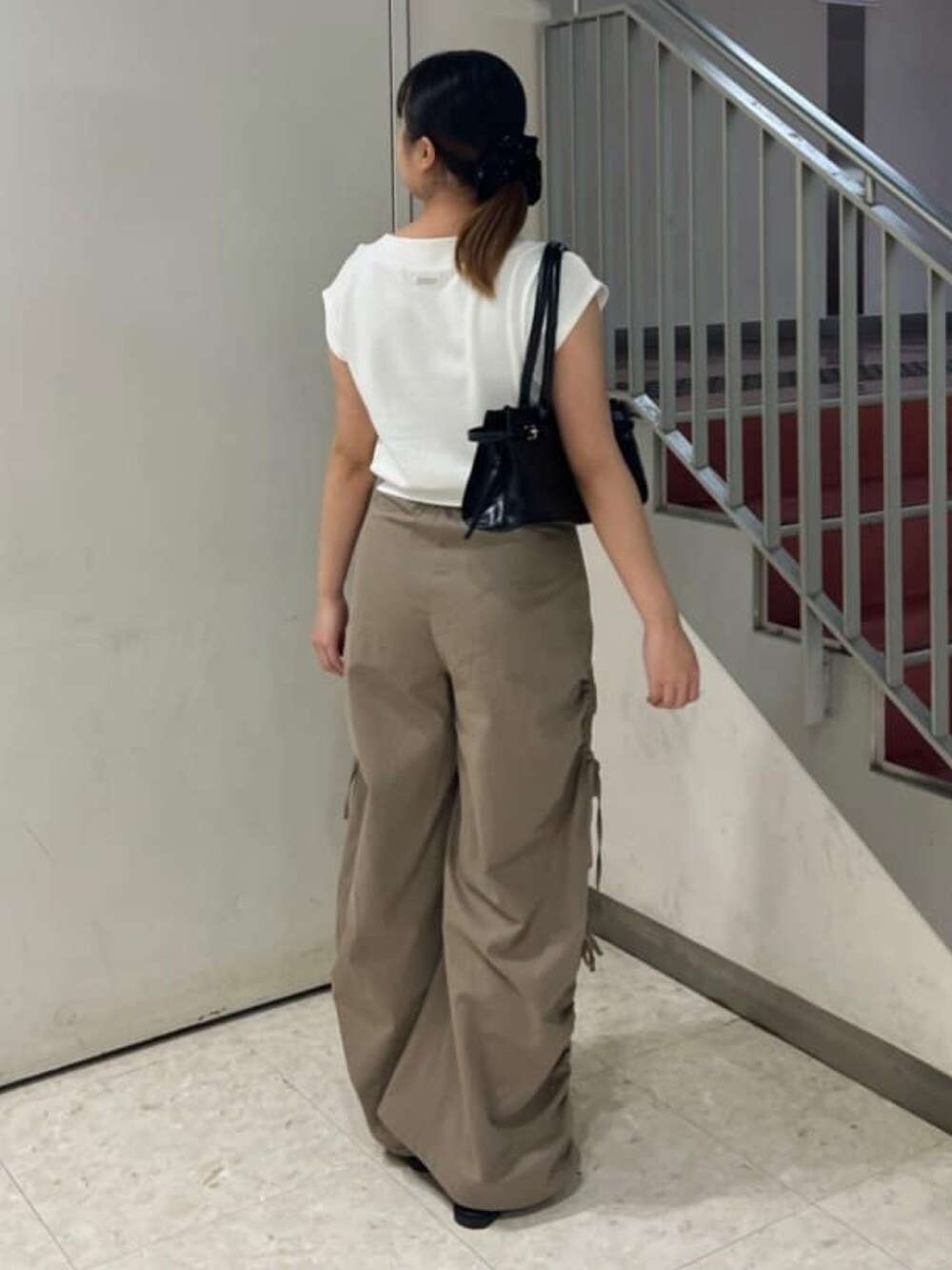 グレー系のスウェット、ベージュ系のカーゴパンツを着用したレディースの夏コーディネートの2枚目の写真