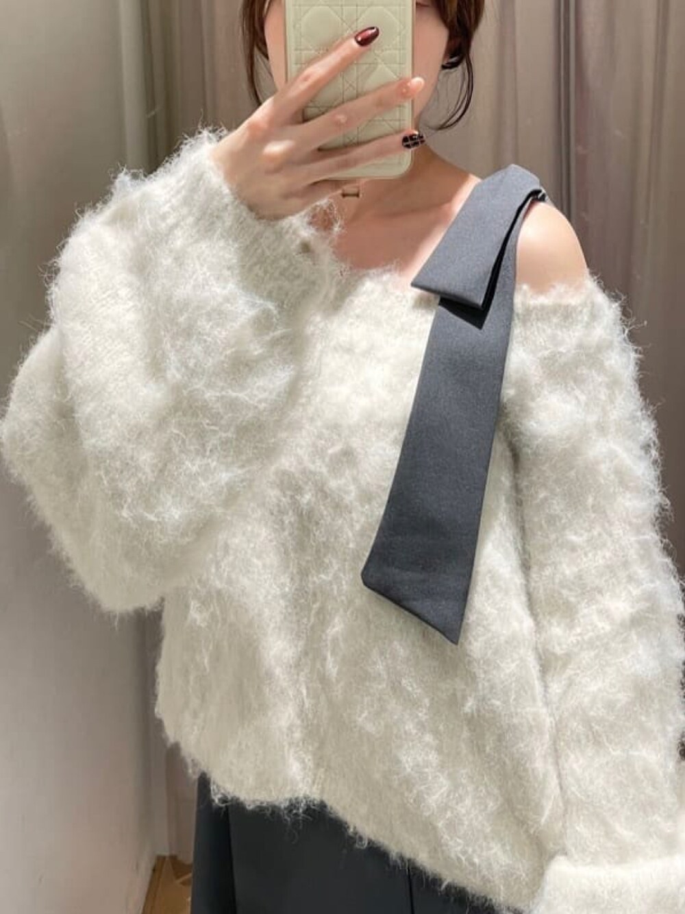 グレー系のワンピース、ホワイト系のニット/セーターを着用したレディースの冬コーディネートの3枚目の写真