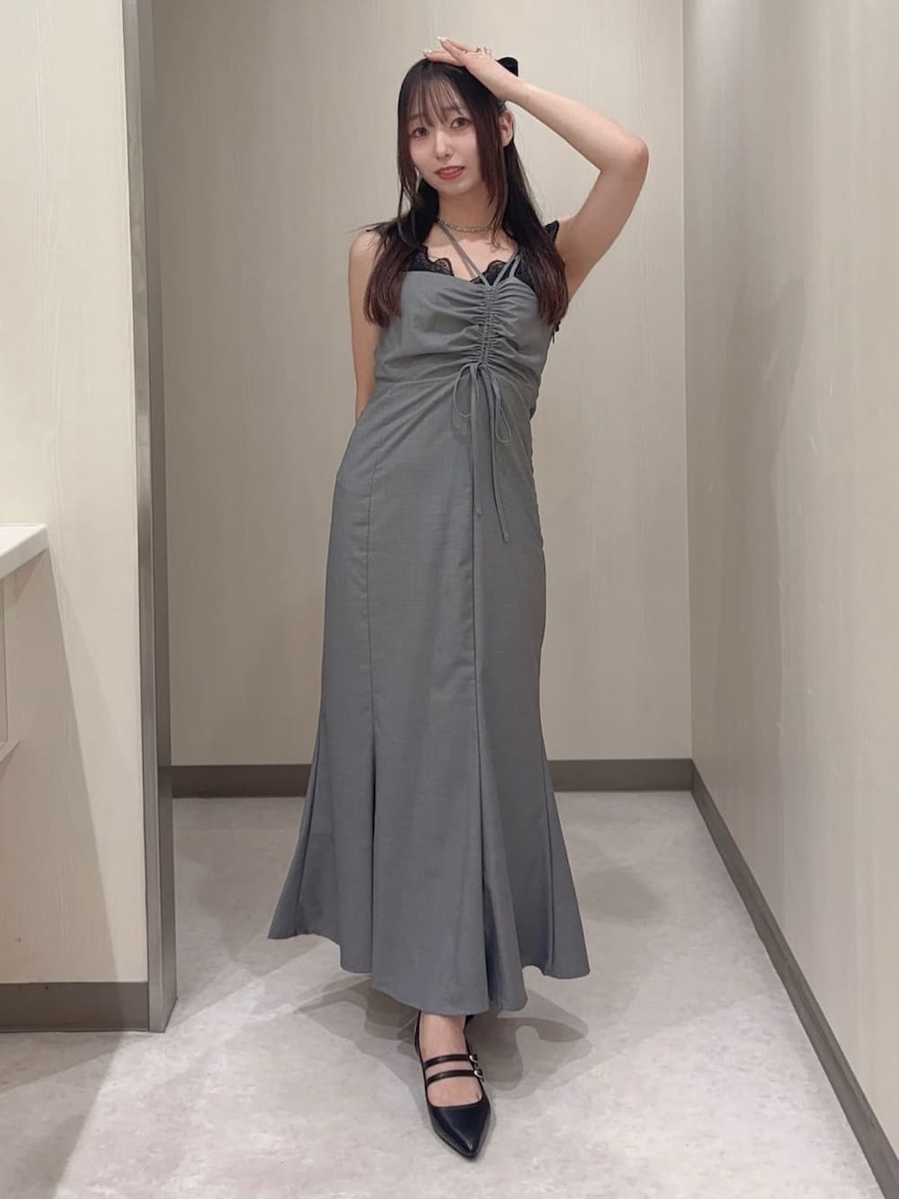 グレー系のワンピース、ブラック系のカーディガン/ボレロ、ブラック系のパンプスを着用したレディースの夏コーディネートの3枚目の写真