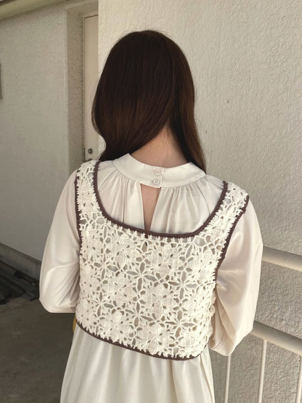 ホワイト系のワンピース、イエロー系のボストンバッグ、ブルー系のデニムパンツを着用したレディースの春コーディネートの4枚目の写真