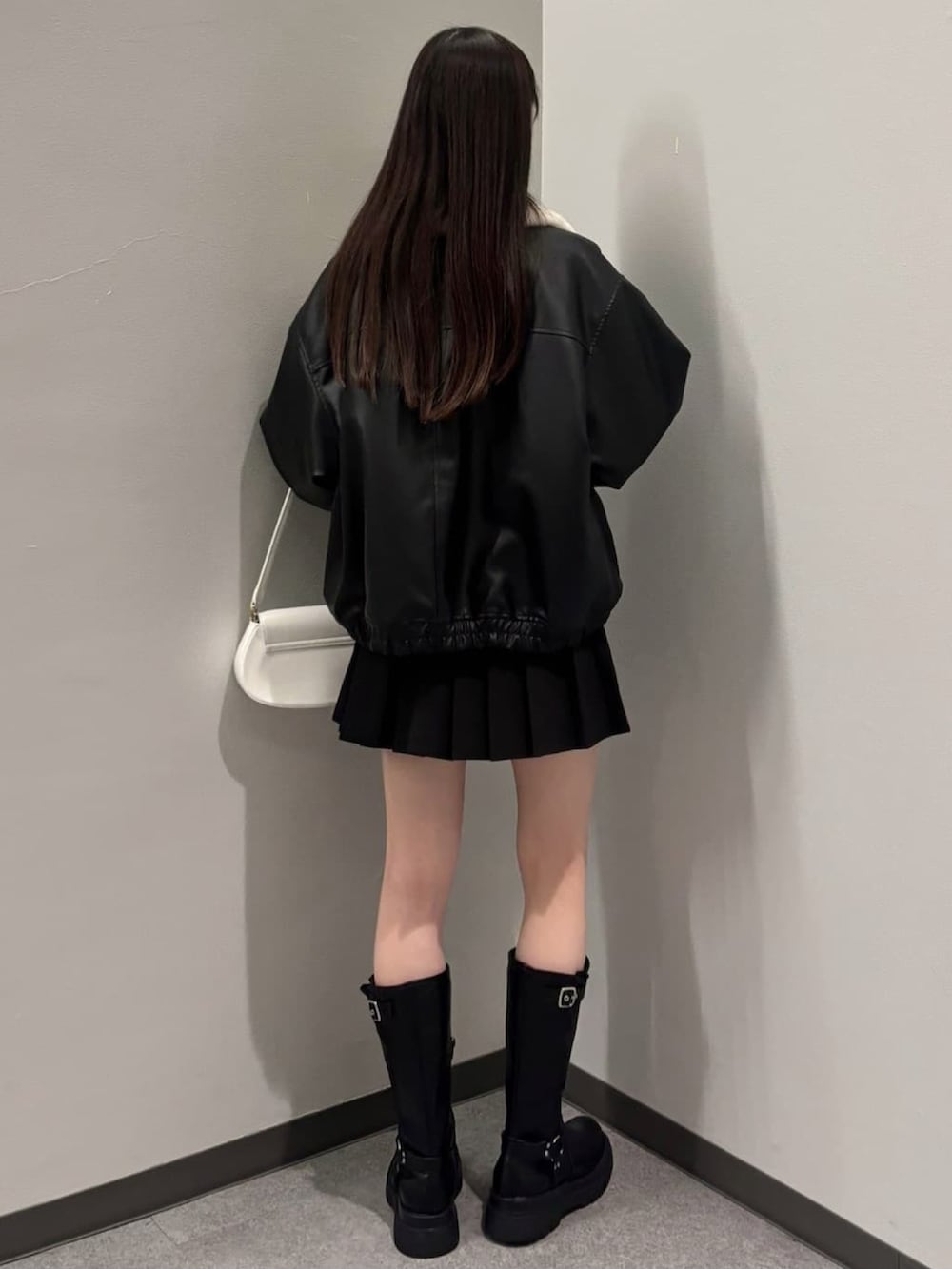 ブラック系のブルゾン、ブラック系のブーツ、ブラック系のスカートを着用したレディースの冬コーディネートの3枚目の写真