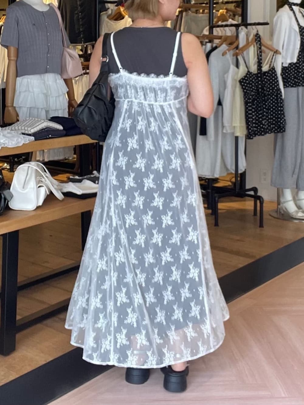 グレー系のワンピース、グレー系のサンダル、ブラック系のショルダーバッグを着用したレディースの夏コーディネートの3枚目の写真