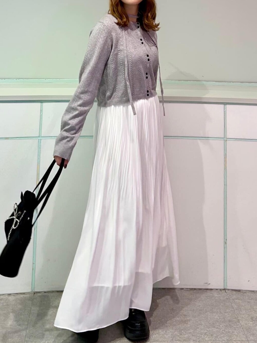 グレー系のカーディガン/ボレロ、ホワイト系のスカートを着用したレディースの秋コーディネートの2枚目の写真