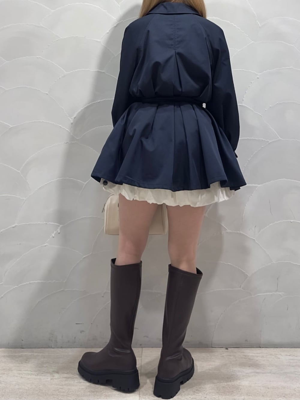 ブルー系のトレンチコート、ピンク系のカーディガン/ボレロを着用したレディースの冬コーディネートの4枚目の写真