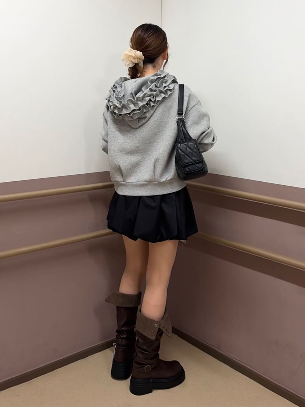 グレー系のパーカー、ブラック系のショルダーバッグ、ブラック系のスカートを着用したレディースの秋コーディネートの3枚目の写真