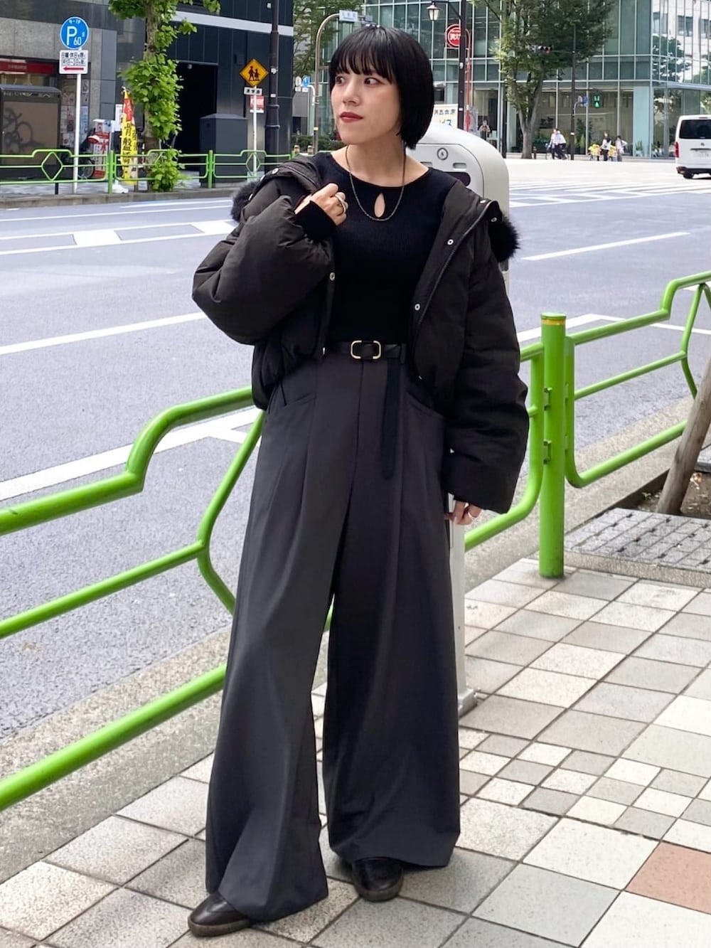 ブラック系のブルゾン、グレー系のスラックスを着用したレディースの秋コーディネートの2枚目の写真