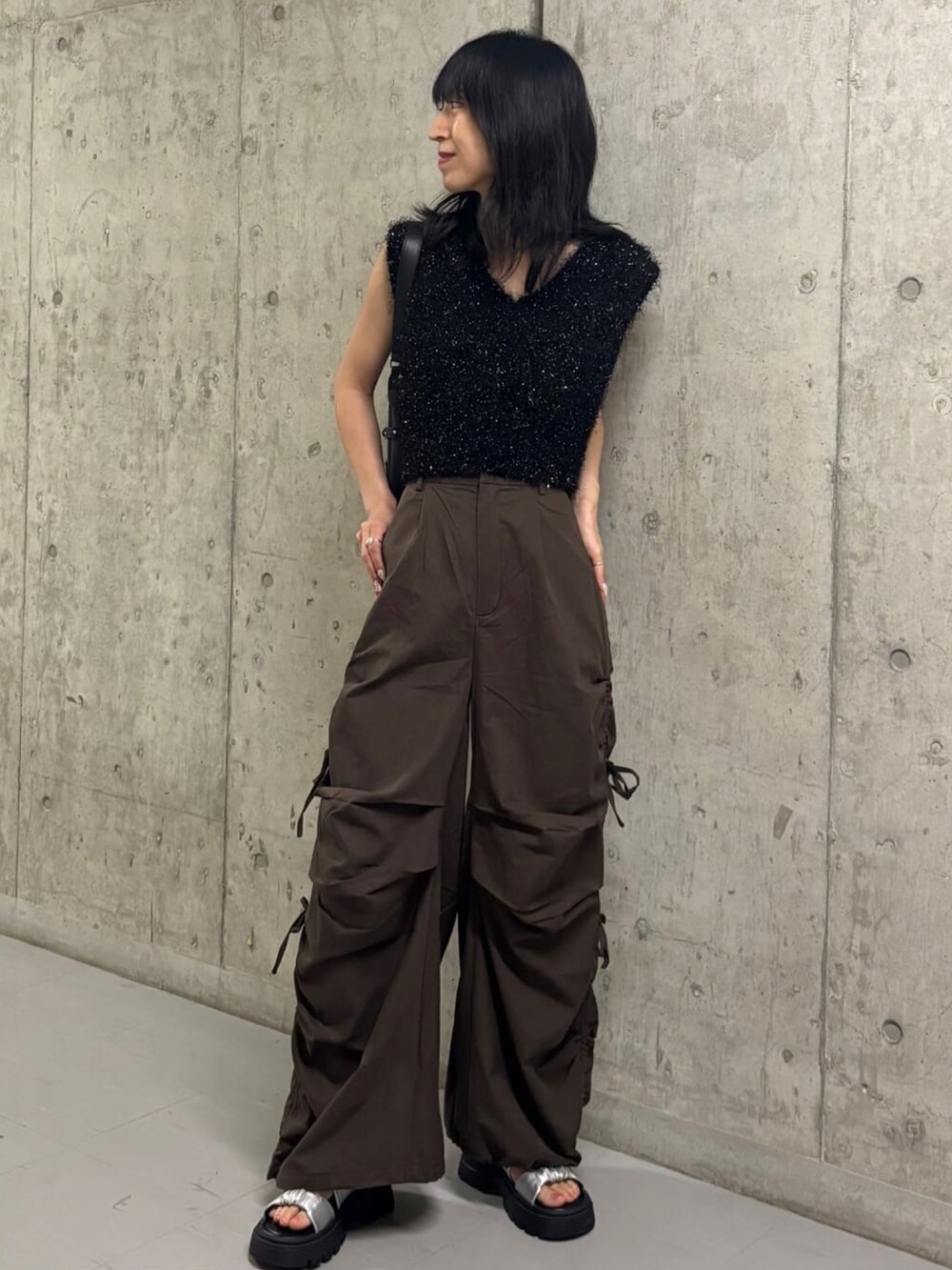 ブラック系のベスト、ブラウン系のカーゴパンツを着用したレディースの夏コーディネートの3枚目の写真
