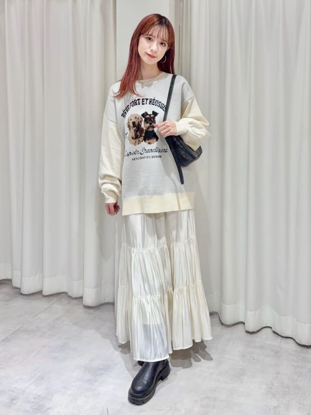 グレー系のニット/セーター、ホワイト系のスカートを着用したレディースの秋コーディネートの3枚目の写真