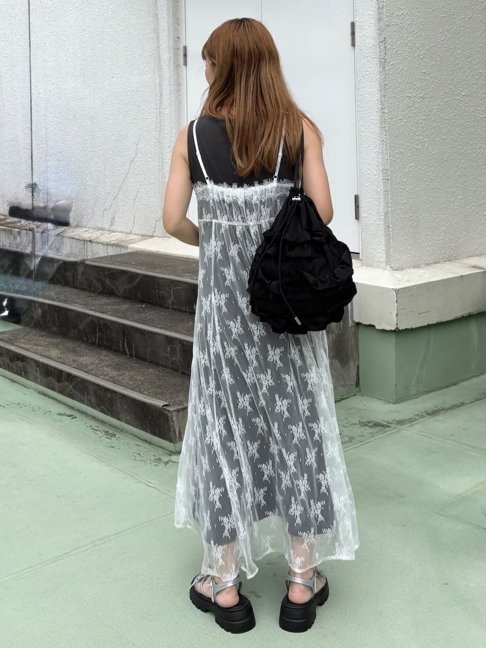 グレー系のワンピース、ブラック系のショルダーバッグ、グレー系のサンダルを着用したレディースの夏コーディネートの3枚目の写真