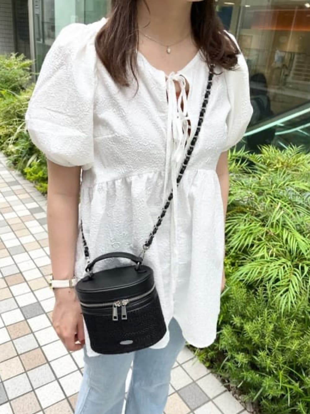 ホワイト系のシャツ/ブラウス、ブルー系のデニムパンツ、ブラック系のショルダーバッグを着用したレディースの夏コーディネートの3枚目の写真