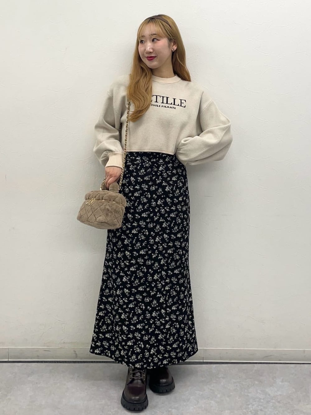 ホワイト系のニット/セーター、ブラック系のスカート、ベージュ系のショルダーバッグを着用したレディースの冬コーディネートの2枚目の写真