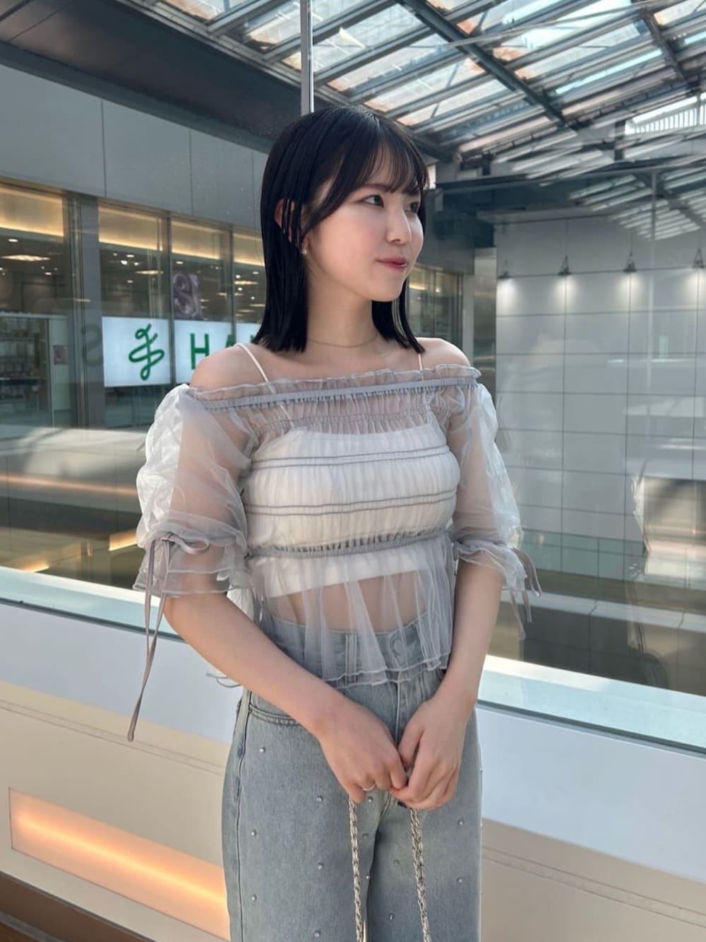 グレー系のTシャツ/カットソー、ブルー系のデニムパンツ、ホワイト系のサンダルを着用したレディースの夏コーディネートの2枚目の写真