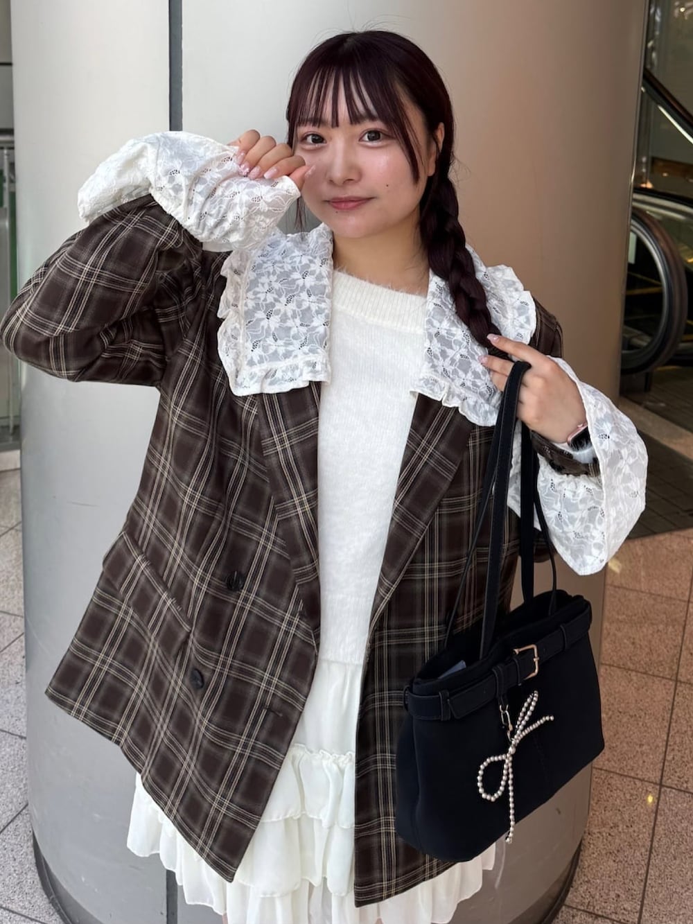 ブラウン系のテーラードジャケット、ホワイト系のスカート、ブラック系のショルダーバッグを着用したレディースの秋コーディネートの3枚目の写真