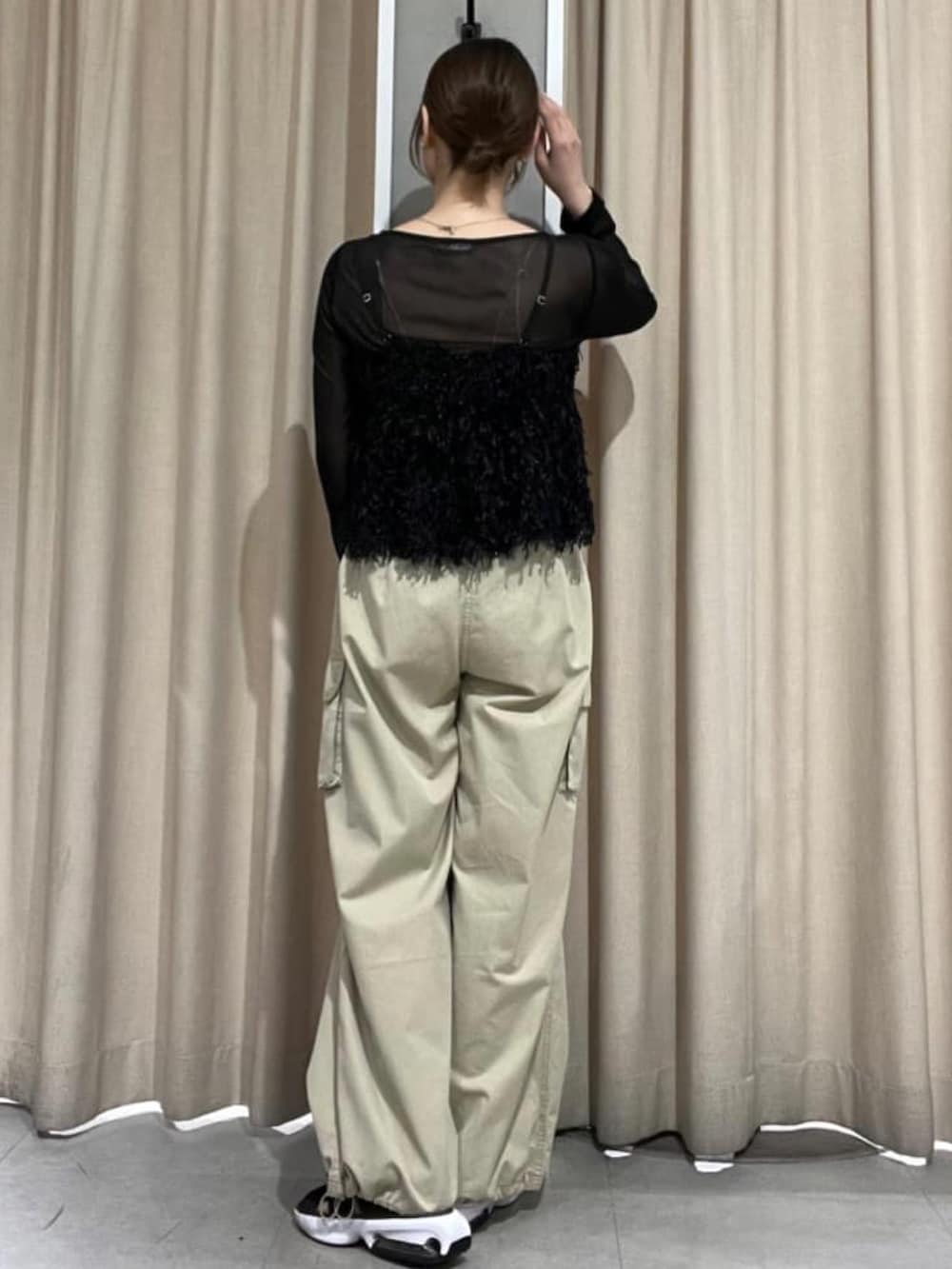 ブラック系のアンサンブル、ベージュ系のカーゴパンツを着用したレディースの秋コーディネートの3枚目の写真