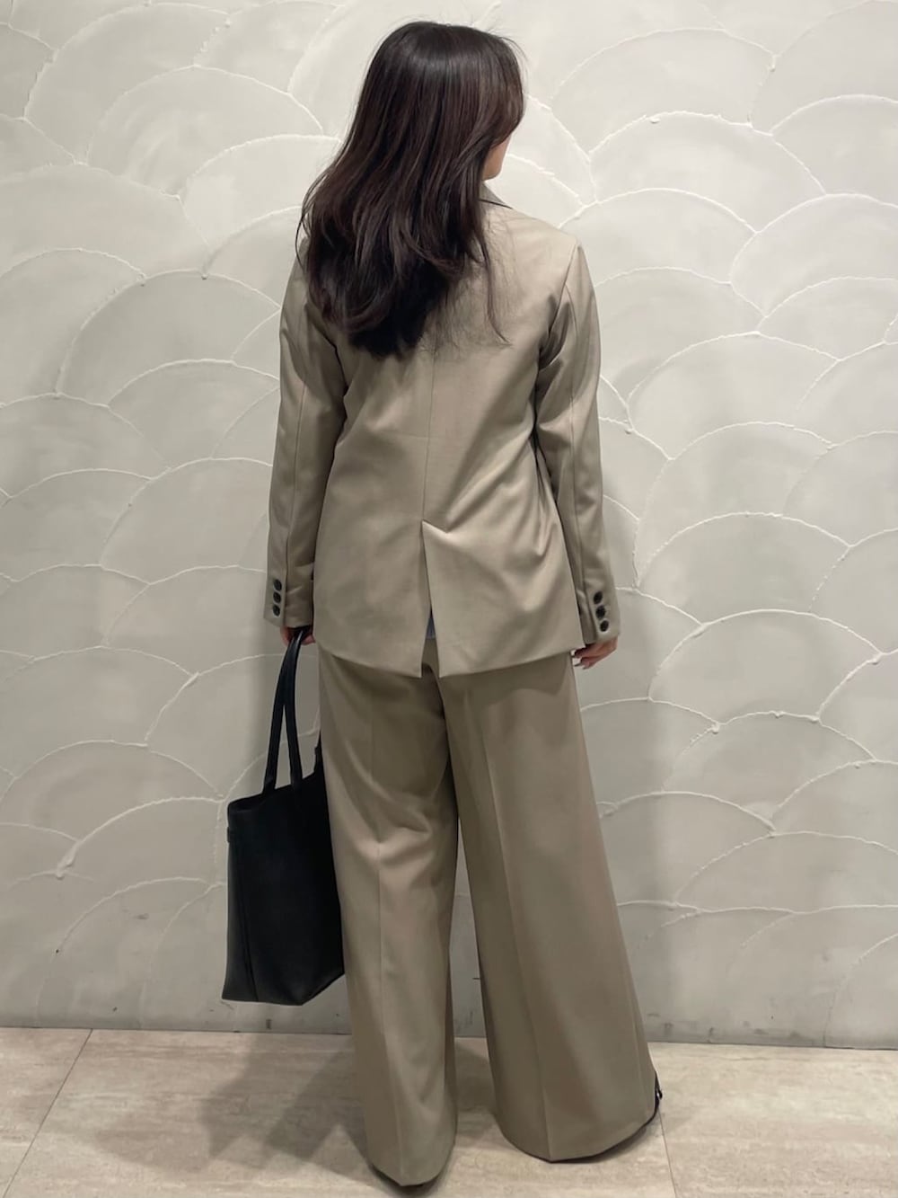 ベージュ系のテーラードジャケット、ベージュ系のスラックス、ホワイト系のシャツ/ブラウスを着用したレディースの春コーディネートの3枚目の写真
