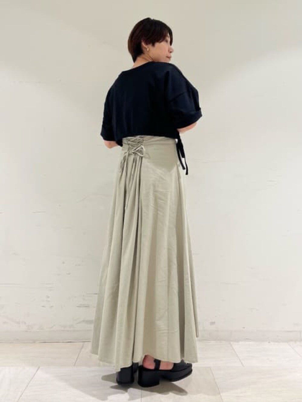 ブラック系のTシャツ/カットソー、グリーン系のスカートを着用したレディースの夏コーディネートの2枚目の写真