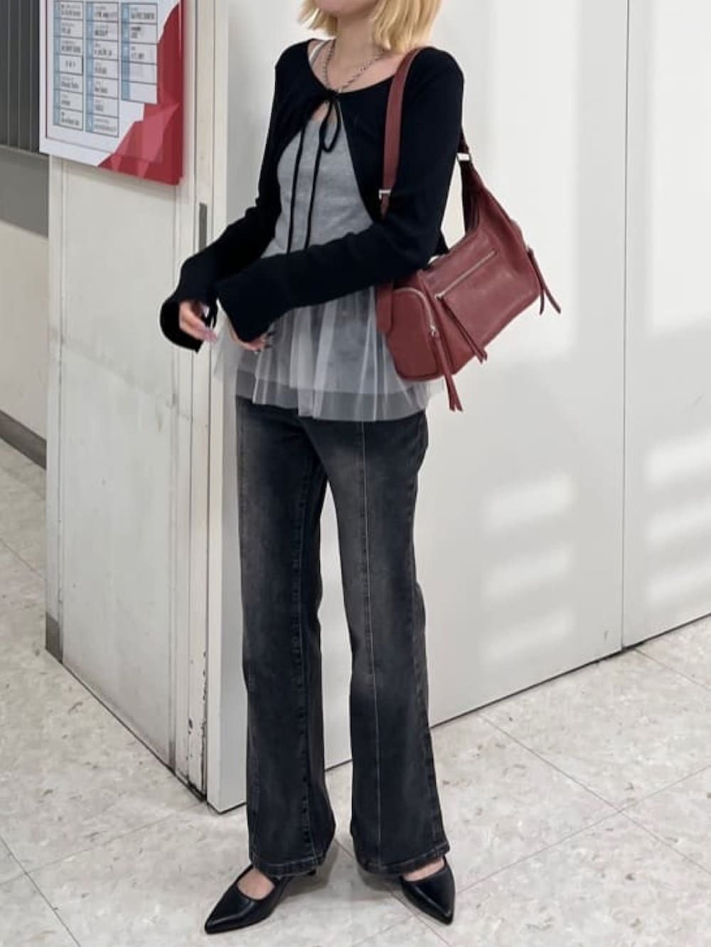 ブラック系のアンサンブル、グレー系のデニムパンツ、ブラック系のパンプスを着用したレディースの夏コーディネートの2枚目の写真