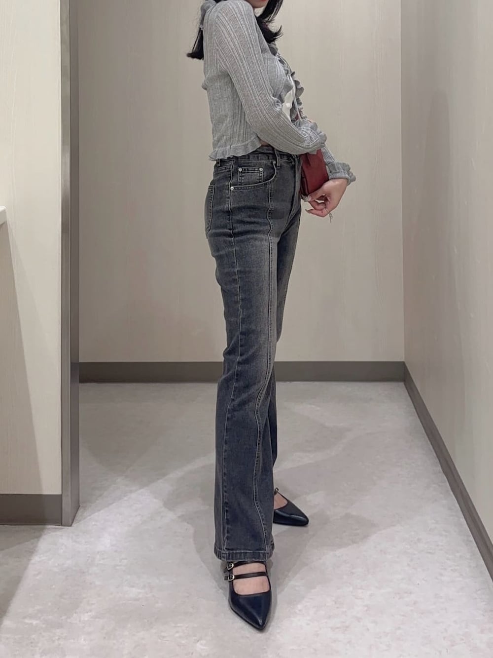 ブラック系のカーディガン/ボレロ、グレー系のデニムパンツ、レッド系のハンドバッグを着用したレディースの夏コーディネートの2枚目の写真