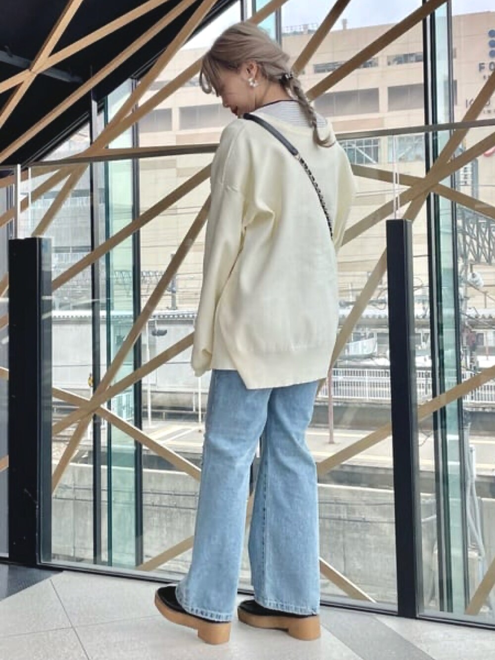 ホワイト系のカーディガン/ボレロ、ホワイト系のTシャツ/カットソー、ブルー系のデニムパンツを着用したレディースの冬コーディネートの2枚目の写真