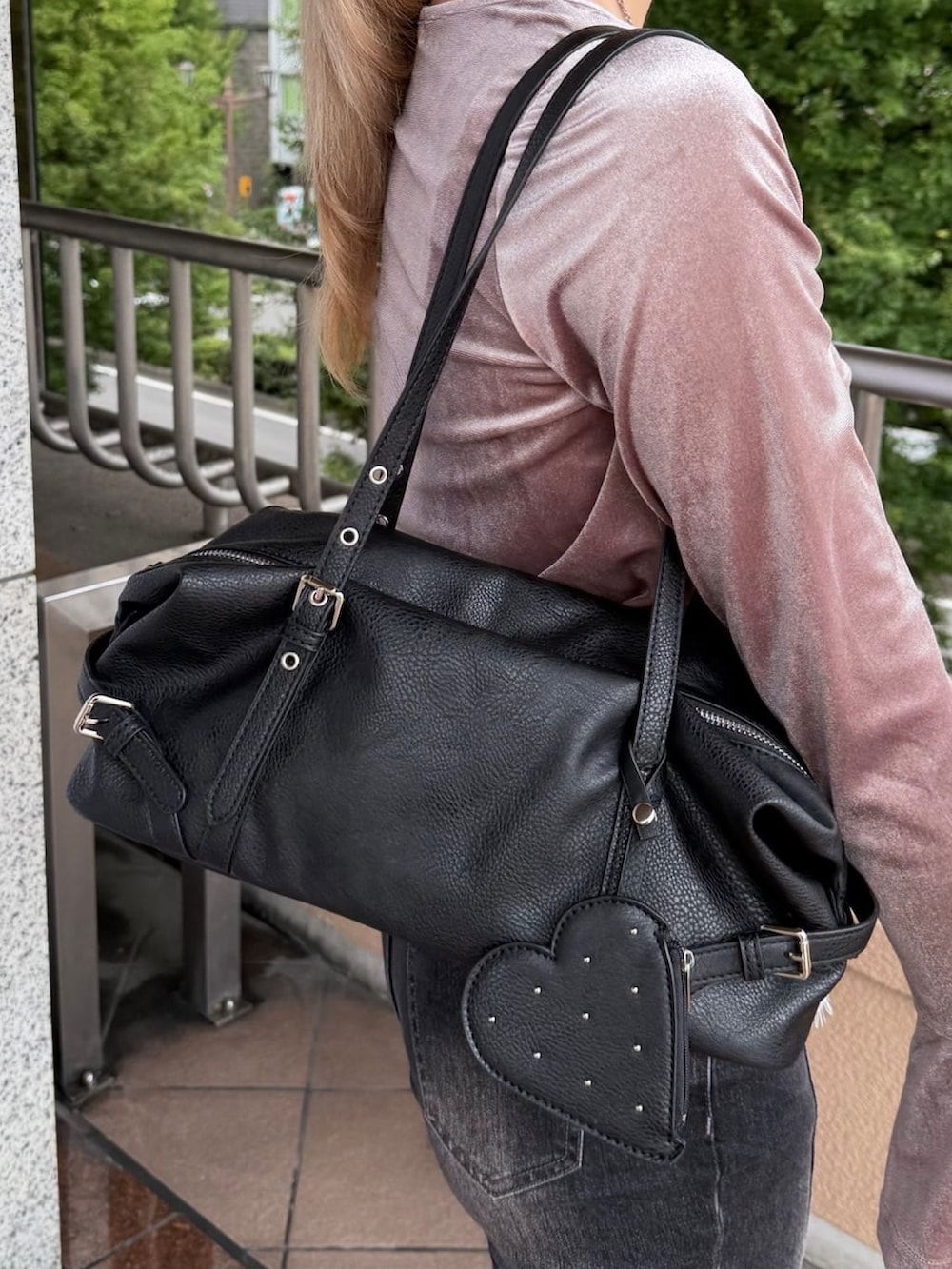 グレー系のデニムパンツ、ブラック系のパンプス、ブラック系のボストンバッグを着用したレディースの秋コーディネートの2枚目の写真